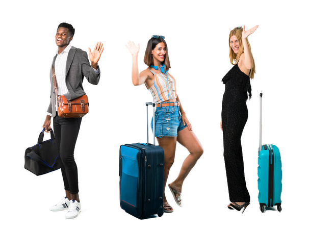 Personas que viajan con maletas sonriendo y saludando
 - Foto, Imagen