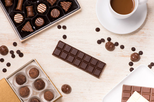 Glass of chocolate milk and variety chocolates  on table - Photo, Image