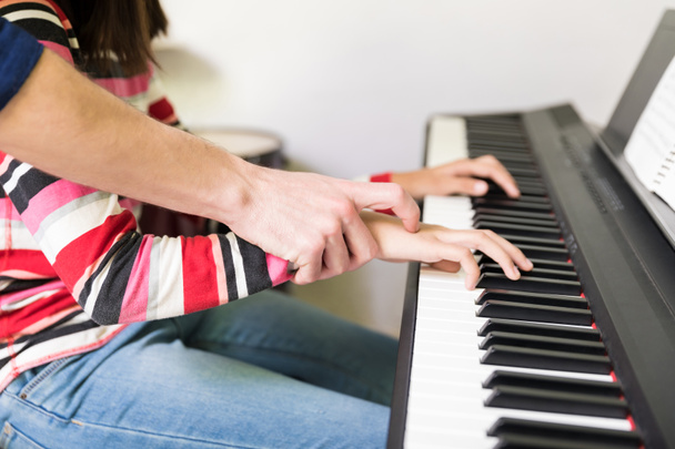 Tutor che dà lezioni di pianoforte elettrico alla ragazza adolescente in classe extrascolastica a scuola
 - Foto, immagini