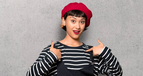 Young woman with beret with surprise facial expression over textured wall - Photo, Image