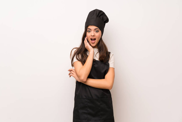 Teenager chef  over white wall surprised and shocked while looking right - Photo, Image