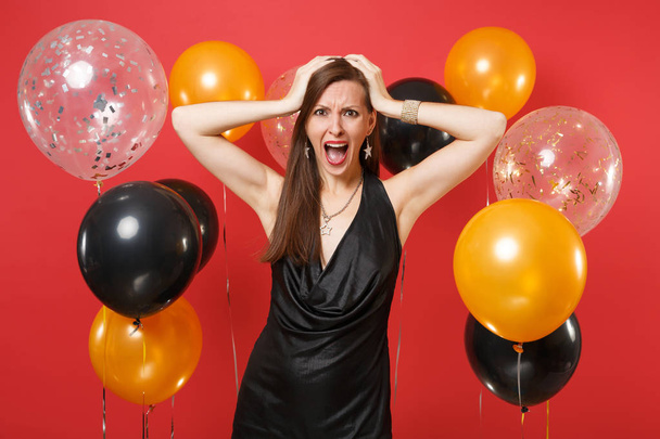 Irritated young woman in black dress screaming, celebrating, put - Photo, Image