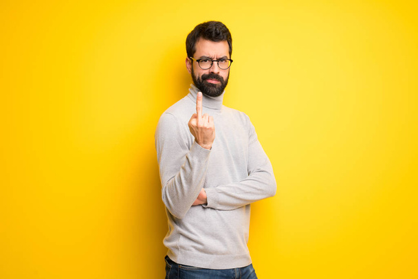 Man with beard and turtleneck making horn gesture - Photo, Image