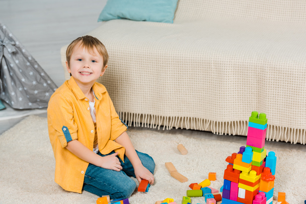 adorable preschooler boy playing with colorful building blocks at home - Fotoğraf, Görsel