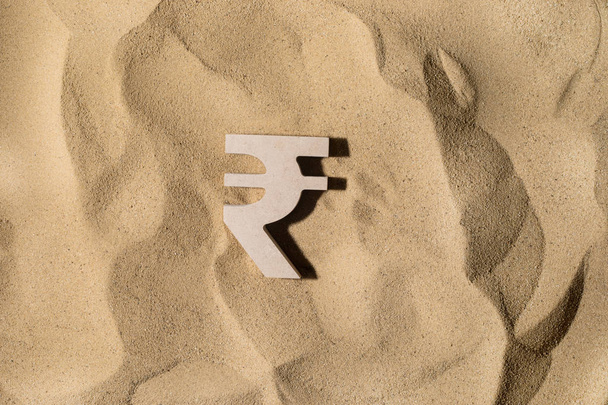 Signo de rupia en la arena
 - Foto, imagen