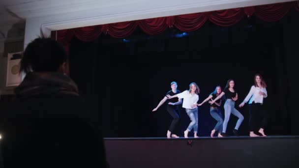 Teatterilava. Ihmiset harjoittelevat kollektiivista tanssia näyttämöllä
 - Materiaali, video