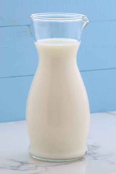 Νοστιμότατο φρέσκο γάλα, μία από τις πρωτογενείς πηγές της διατροφής σε vintage ιταλικό μάρμαρο της Καράρας, αγρόκτημα στυλ κουζίνα. - Φωτογραφία, εικόνα