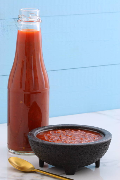 Artisan mexican hot salsa in vintage talavera bowl, with a delicious fresh hot flavor,  on vintage carrara marble table. - Photo, Image