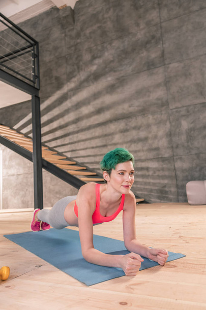 Fit woman with short hair cut doing morning plank after yoga - Zdjęcie, obraz