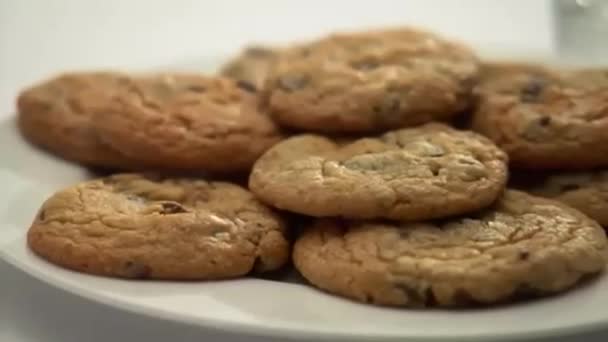 πιάτο με μπισκότα και γάλα που χύνεται - Πλάνα, βίντεο