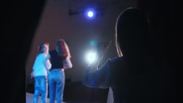 A theater stage. A performance. Two girls acting on the stage and woman from a backstage snaps her fingers - Footage, Video