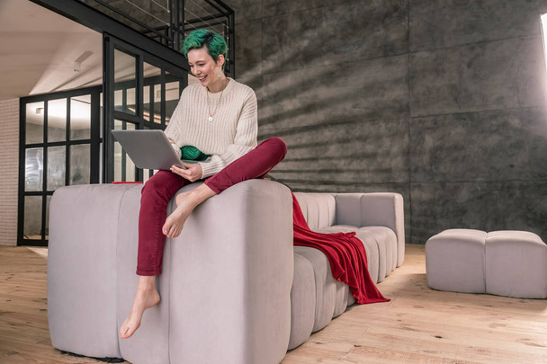 Green-haired woman wearing beige sweater working from home - Photo, image