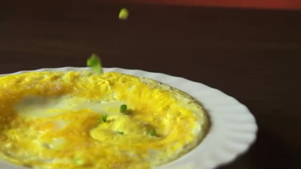 nakrájená zelená cibule padá na omeletu - Záběry, video