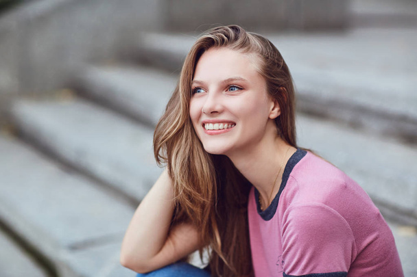 A blond happy girl smiles in an urban style.  - Fotoğraf, Görsel