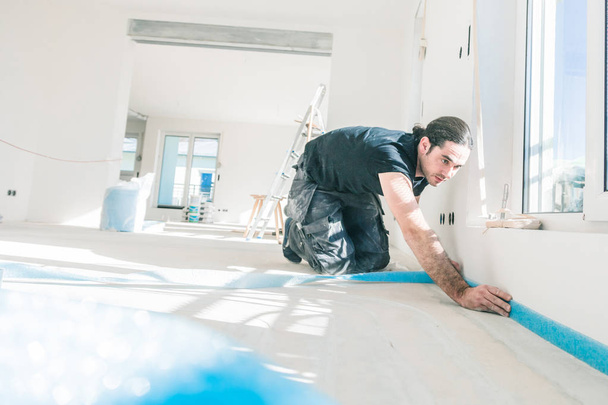 professional male worker gluing edge insulation strip during home renovation - Fotografie, Obrázek