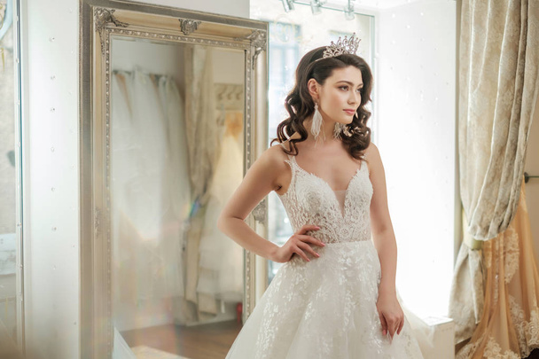 Красивая невеста выбирает свадебное платье в свадебном салоне
 - Фото, изображение