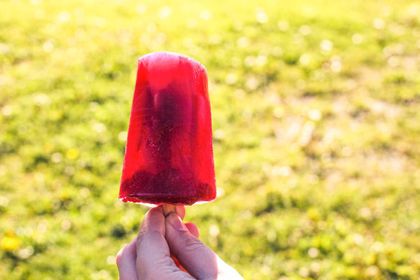 Red fruit popsicle. Ice cream on wooden stick. - Zdjęcie, obraz