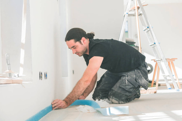 professional worker gluing edge insulation strip during home renovation - Фото, зображення