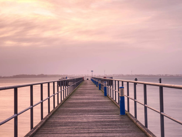 穏やかな早朝のバルト海沿岸の長い桟橋. - 写真・画像