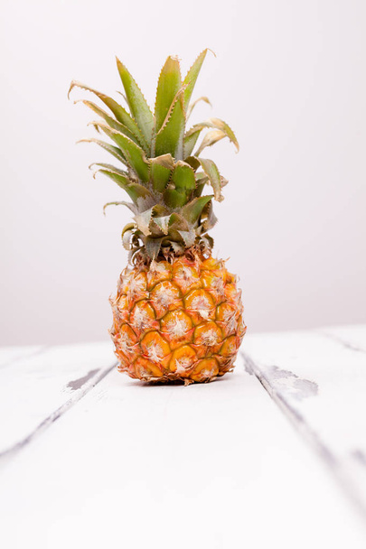 one pineapple on white wooden table - Zdjęcie, obraz