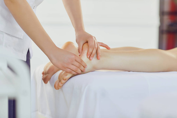Therapist massaging feet of client lying - Foto, Imagem