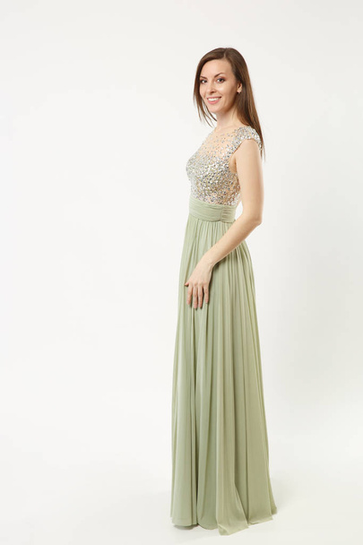 Full length photo fashion model woman wearing elegant evening dress olive gown posing isolated on white wall background studio portrait. Brunette long hair girl. Mock up copy space. Side profile view. - Foto, imagen
