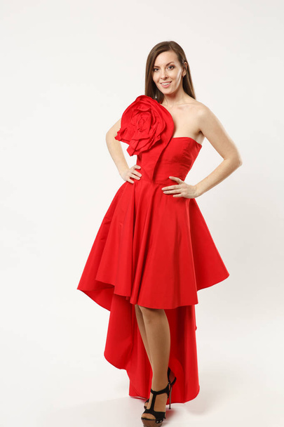 Full length photo of fashion model woman wearing elegant evening dress gown posing isolated on white wall background studio portrait. Brunette long hair girl. Mock up copy space. Red dress face view. - Foto, Imagem