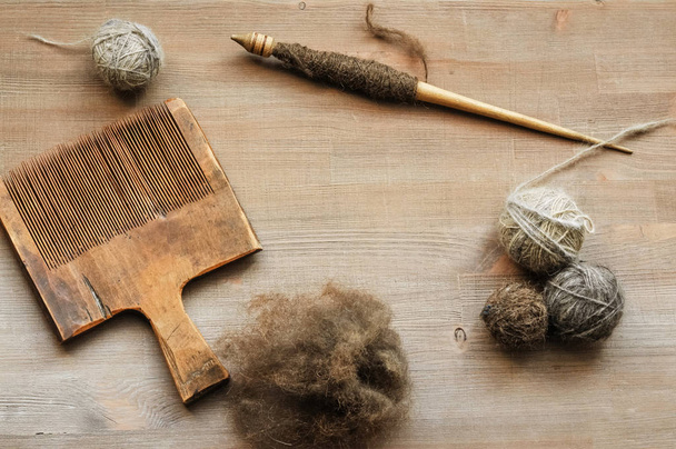 Ancient female craft tools on brown wooden background - Фото, изображение