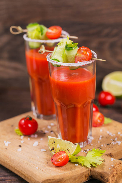 Two glasses of tomato juice decorated with fresh tomatoes, cucum - Фото, зображення