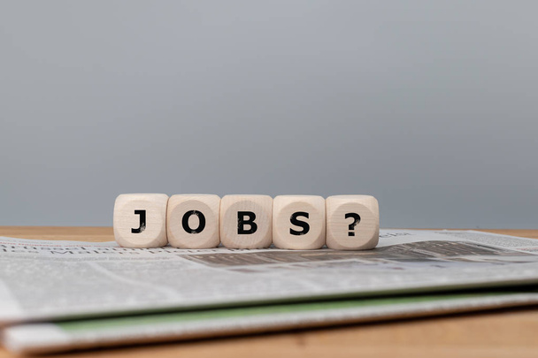 Dice form the word "jobs" with a question mark on top of a newsp - Foto, afbeelding