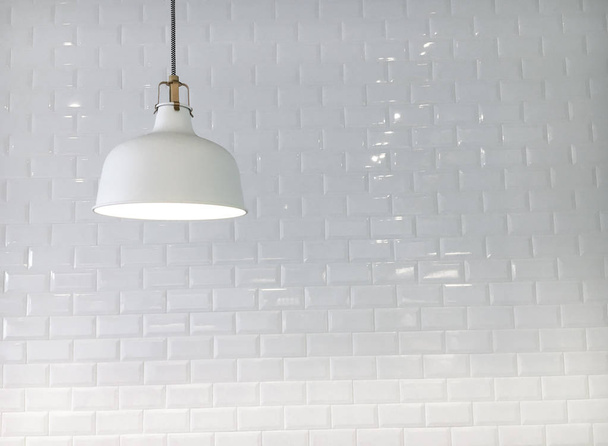 Close-up shot van eenvoudige lamp opknoping voor witte muur - Foto, afbeelding