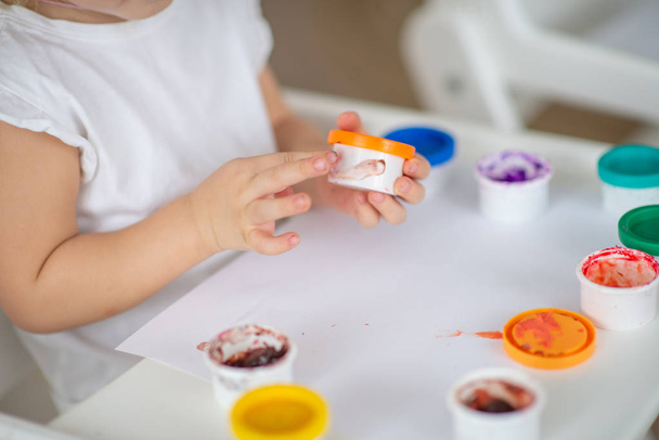 dítě kreslí prstem barvy detail ruky na bílém papíře - Fotografie, Obrázek