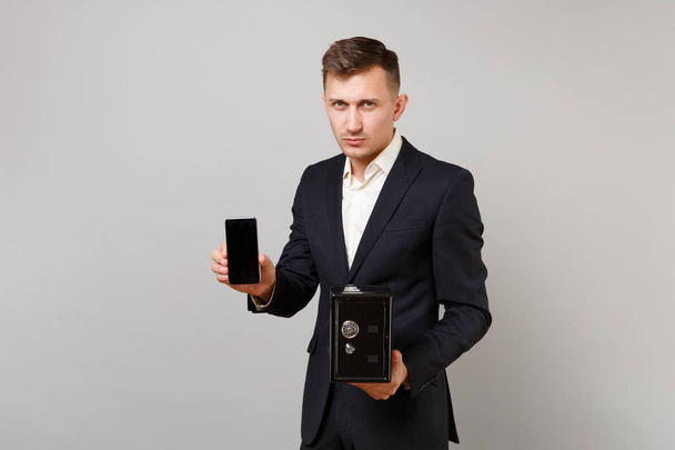 Sérieux jeune homme d'affaires tenir téléphone portable avec vide sc vide
 - Photo, image