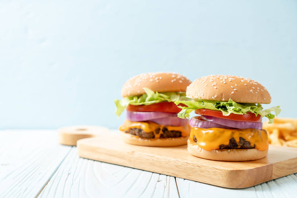 frische leckere Rindfleisch-Burger mit Käse und Pommes frites - Foto, Bild