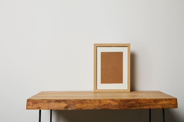 blank square frame on wooden textured table at home - Foto, immagini