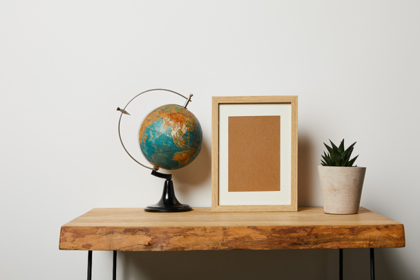 globe near frame and plant in pot on wooden table - Photo, Image