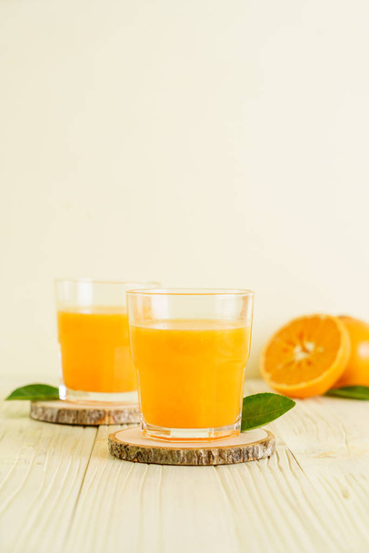 Fresh orange juice on wood background - Fotó, kép