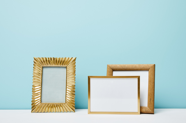 blank decorative frames near blue wall  - Zdjęcie, obraz