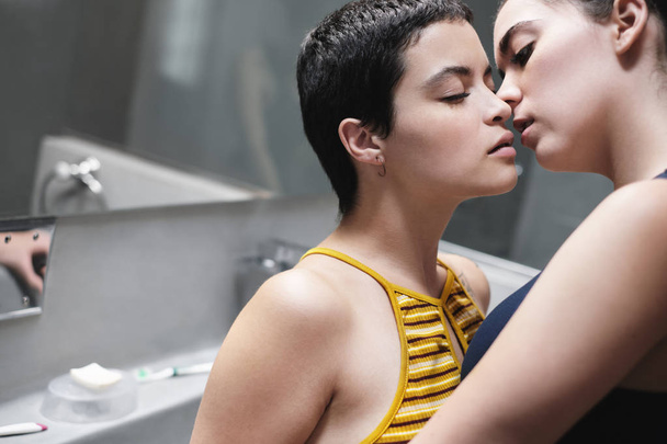 Liebesflirt zwischen lesbischen Frauen, die sich im Badezimmer küssen - Foto, Bild