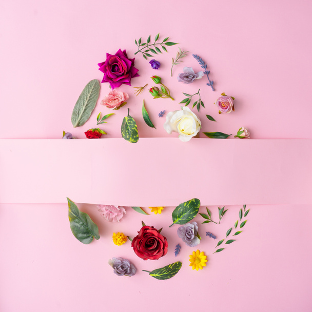 Easter egg shape made with spring flowers and leaves on pastel pink background, Minimal Happy Easter concept - 写真・画像