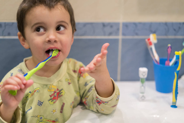 Χαριτωμένο μικρό αγόρι βούρτσισμα των δοντιών. μικρό αγοράκι με βούρτσα δοντιών. - Φωτογραφία, εικόνα