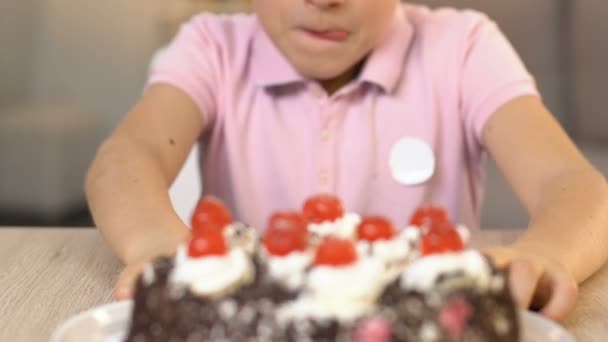 Happy boy eating cherry from top of cream cake, unhealthy diet, gastroenterology - 映像、動画