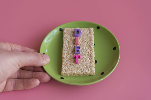 ropogós kenyeret, kenyeret és egy pohár vizet a felirat deet, egy rózsaszín háttér. Fogyás és az egészséges életmód fogalma. - Fotó, kép