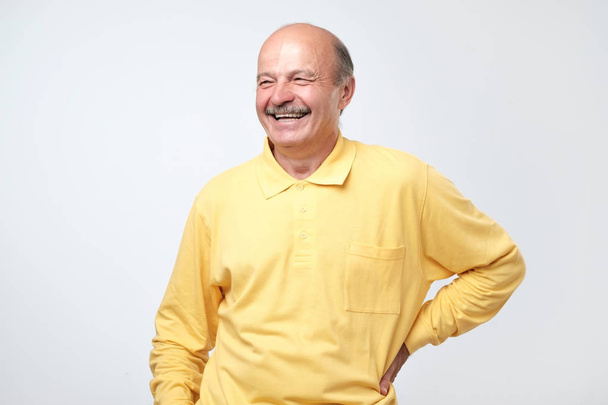 Mature adult man laughing looking at the camera over white background. - Foto, Bild