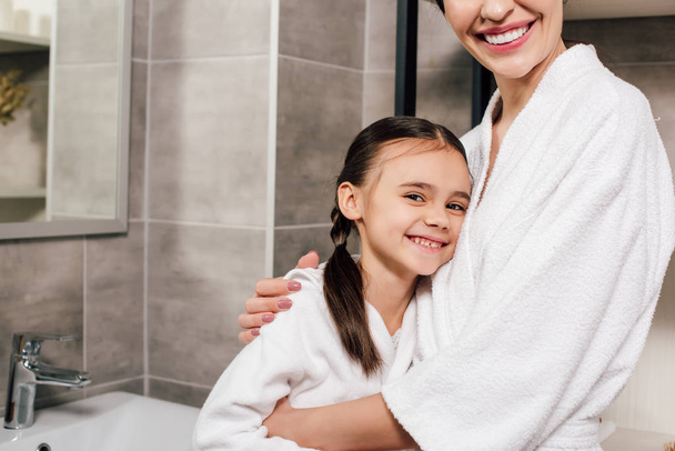 daughter and mother hugging and smiling in bathroom - Foto, immagini
