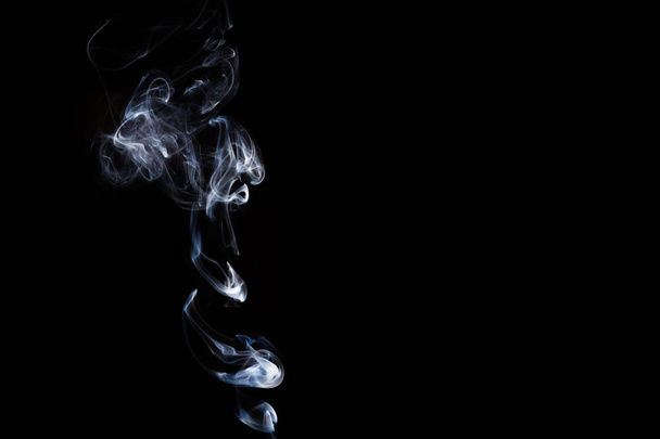 Smoke incense on a black background, abstract photo with swirls in the air - Фото, зображення