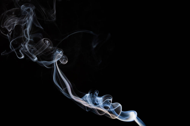 Smoke incense on a black background, abstract photo with swirls in the air - Foto, imagen