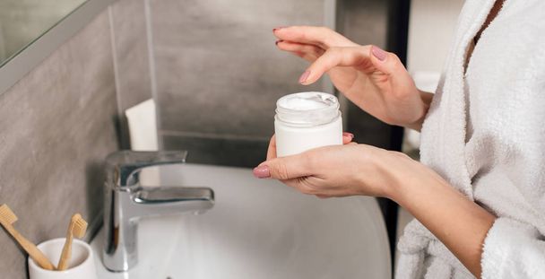 panoramic shot of woman holding container with lotion in bathroom - Φωτογραφία, εικόνα