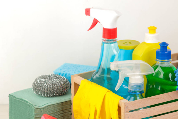Flessen met wasmiddel en schoonmaken van gereedschappen in een bak op een lichte achtergrond. schoonmaken. Reinigingsproducten. Close-up - Foto, afbeelding