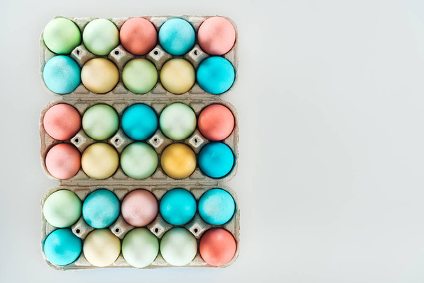 vue de dessus des œufs de Pâques pastel dans des récipients en papier isolés sur gris
 - Photo, image